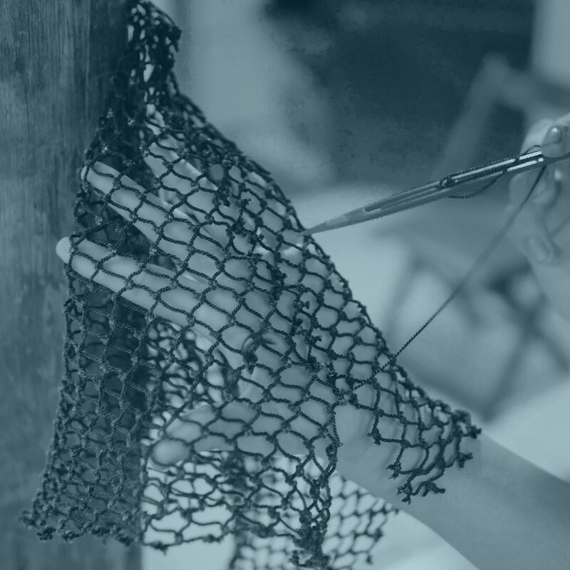 Hands mending a fishing net